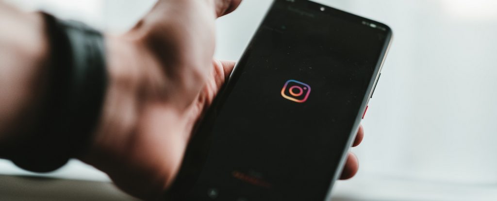 Imagem de uma pessoa segurando um celular no Instagram
